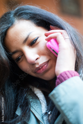 Photo: Young girl speaking at mobile phone. Young girl speaking at mobile phone.