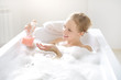 Girl with liquid soap in the bath