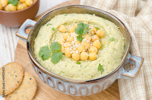 Photo: Hummus with cilantro and crackers, top view Hummus with cilantro and crackers, top view