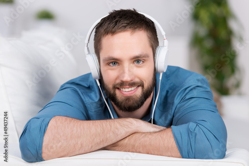 Photo: junger mann hört musik zu hause junger mann hört musik zu hause