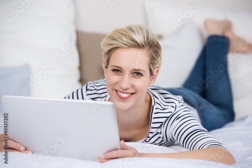 Photo: frau mit laptop im liegt auf dem bett frau mit laptop im liegt auf dem bett