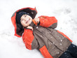 boy lies in snow