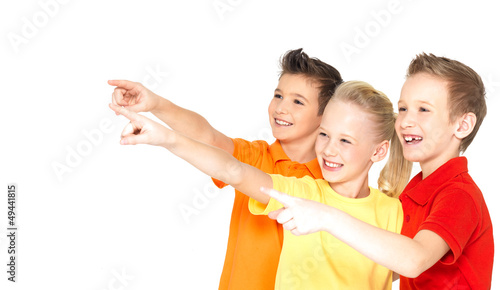 Photo: Happy children point by finger on something away. Happy children point by finger on something away.