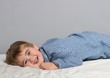 Little boy wearing blue pyjamas in bed