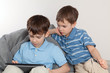 Photo: Two brothers playing on tablet Two brothers playing on tablet
