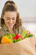 Happy young housewife examines purchases after shopping 