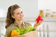 Smiling young housewife examines purchases after shopping 
