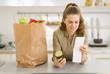 Smiling young housewife examines purchases and check after shopp