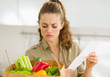 Concerned young housewife examines check after shopping