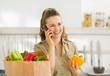 Young housewife sort purchases after shopping and talking mobile