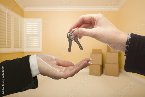 Photo: Woman Handing Over the House Keys Inside Empty Room Woman Handing Over the House Keys Inside Empty Room