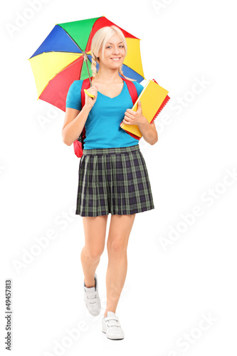 Photo: Full length portrait of a blond female student walking with umbr Full length portrait of a blond female student walking with umbr