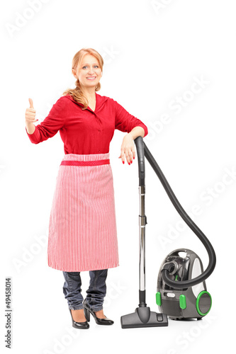 Photo: Blond housewife posing on a vacuum cleaner and giving thumb up Blond housewife posing on a vacuum cleaner and giving thumb up