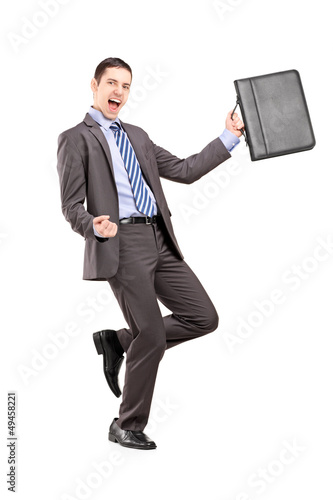 Photo: Happy businessman holding a briefcase and gesturing happiness Happy businessman holding a briefcase and gesturing happiness