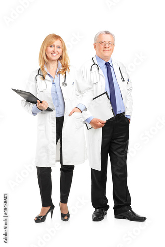 Photo: Full length portrait of a team of doctors holding a clipboard an Full length portrait of a team of doctors holding a clipboard an