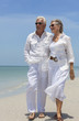 Photo: Happy Senior Couple Walking by Sea on Tropical Beach Happy Senior Couple Walking by Sea on Tropical Beach