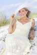 Senior Woman In Sun Dress & Hat At Beach