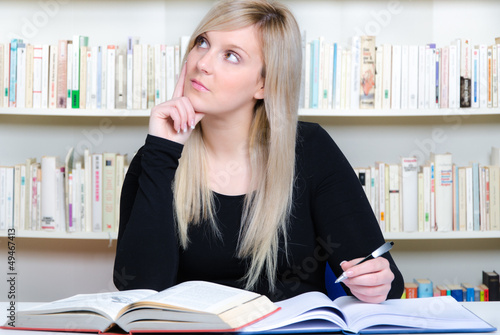 Photo: überlegende studentin schreibt eine hausarbeit überlegende studentin schreibt eine hausarbeit