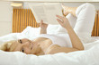 Junge Frau liest Buch im Bett