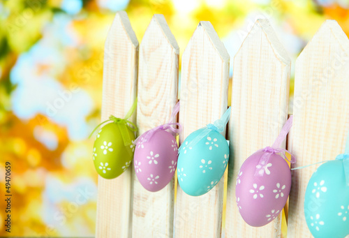 Photo: Art Easter background with eggs hanging on fence Art Easter background with eggs hanging on fence