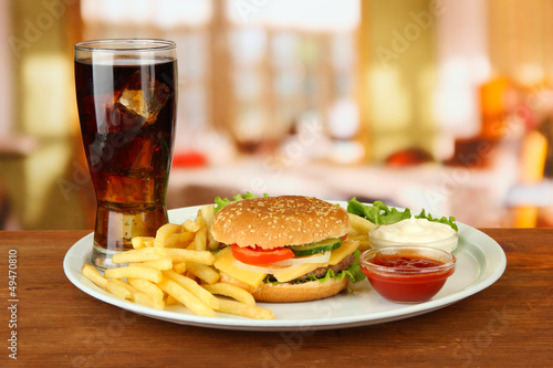 Photo: Tasty cheeseburger with fried potatoes and cold drink, Tasty cheeseburger with fried potatoes and cold drink,