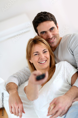 Photo: Sweet couple in sofa watching tv Sweet couple in sofa watching tv