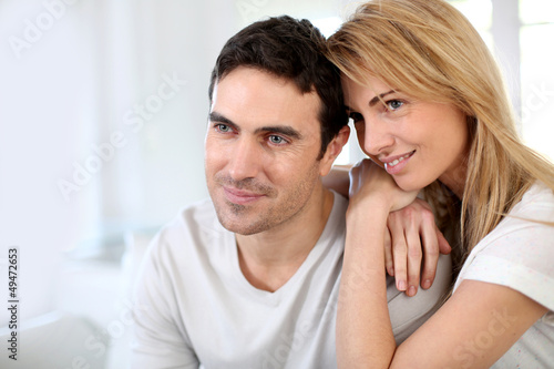Photo: Couple embracing each other on sofa Couple embracing each other on sofa