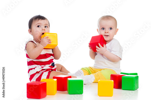 Photo: two babies girls playing together with color toys two babies girls playing together with color toys