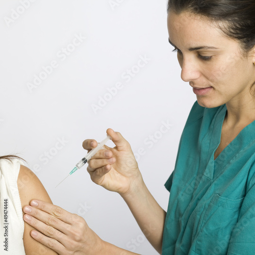 Photo: Junge Krankenschwester impft eine Patientin Junge Krankenschwester impft eine Patientin