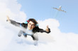 Young businessman flying with parachute on back