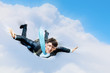Young businessman flying with parachute on back