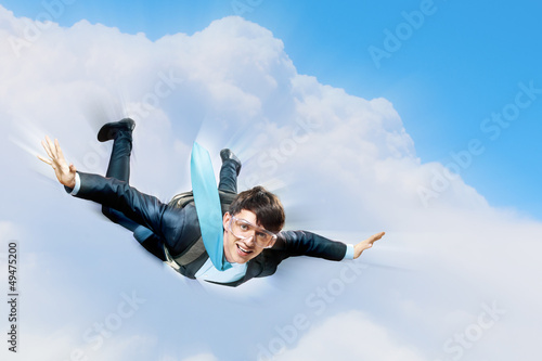 Photo: Young businessman flying with parachute on back Young businessman flying with parachute on back