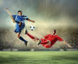 two football players striking the ball