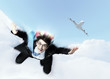 Young businessman flying with parachute on back