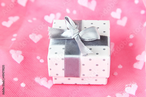 Photo: Color gift box with silver ribbon, on color background Color gift box with silver ribbon, on color background