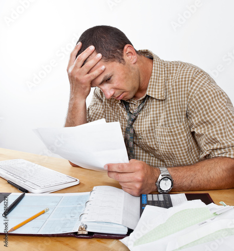 Photo: Worried Young Man with Debt and Bills Worried Young Man with Debt and Bills