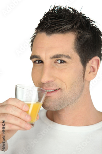 Photo: Man drinking glass of orange juice Man drinking glass of orange juice
