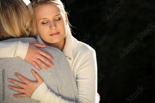 Photo: A mother and her teenage daughter hugging. A mother and her teenage daughter hugging.