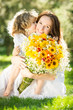 Woman and child holding bouquet of flowers