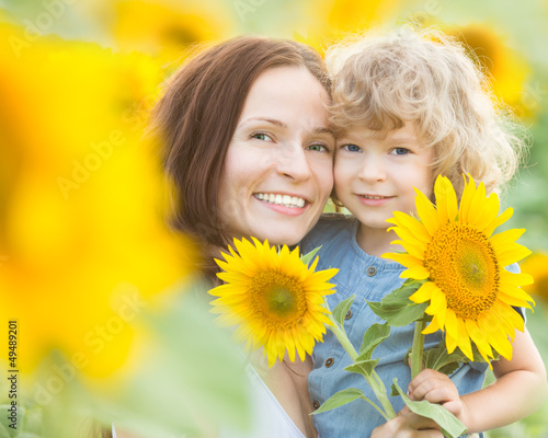 Photo: Happy family with beautiful sunflowers Happy family with beautiful sunflowers