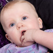 Baby schnullert at own hand