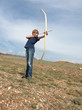 Boy shoots a bow at a target