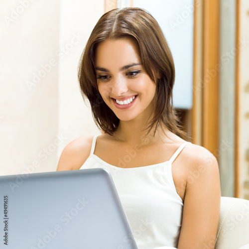 Photo: Cheerfull smiling woman working with laptop Cheerfull smiling woman working with laptop