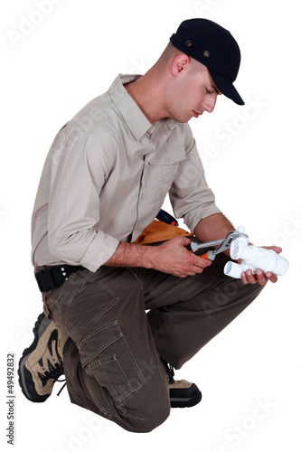 Photo: Plumber using pliers to fasten two parts together Plumber using pliers to fasten two parts together