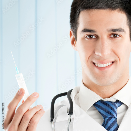 Photo: Cheerful doctor with syringe Cheerful doctor with syringe