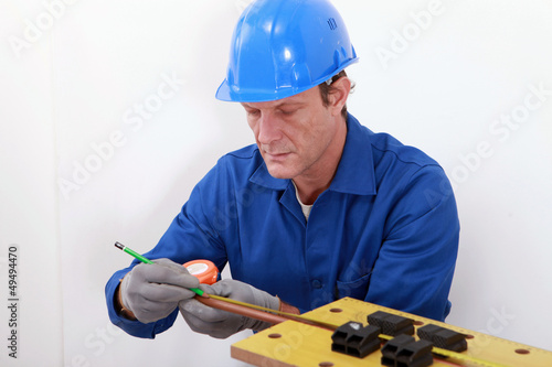 Photo: Man measuring tube Man measuring tube
