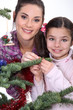 Mother and daughter decorating Christmas tree