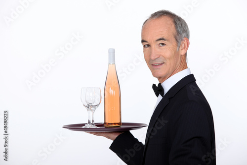 Photo: Waiter carrying wine on tray Waiter carrying wine on tray