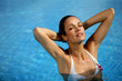 Brunette stood in pool wearing white bikini