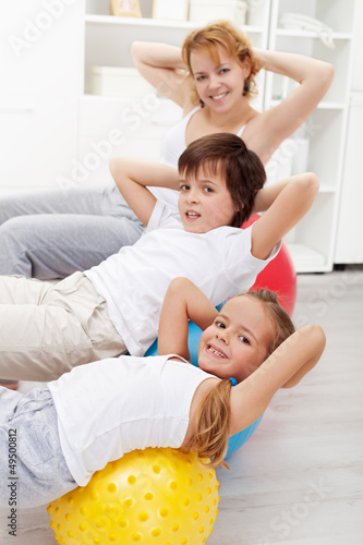 Photo: Kids with their mother doing gymnastic exercises Kids with their mother doing gymnastic exercises